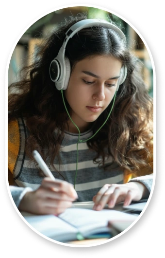 Graduate student comparing documents at clean desk with her laptop open