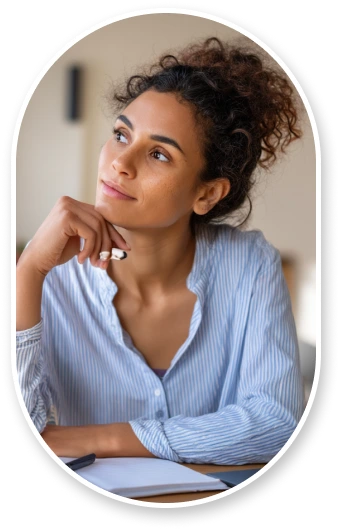 A Graduate student working on financial planning at organized desk with laptop and calculator, taking notes thoughtfully